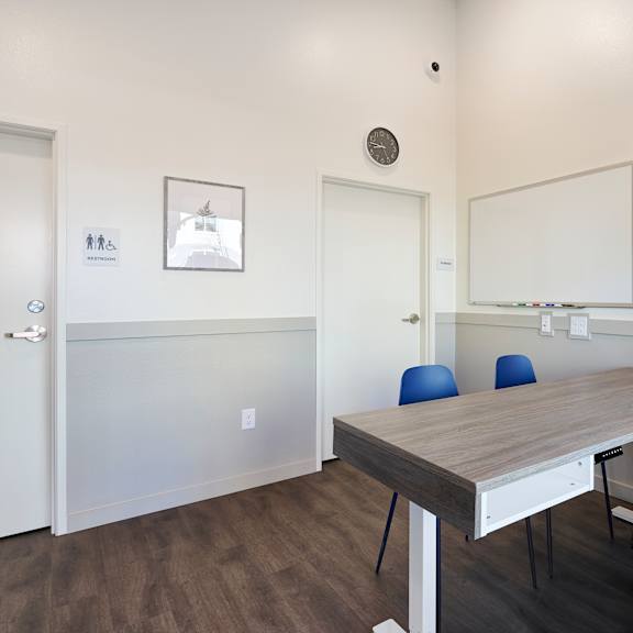 a room with a desk and chairs and a mirror
