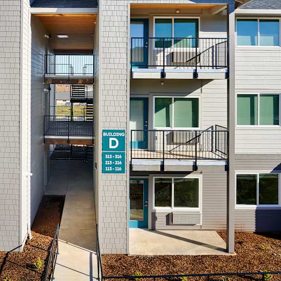 a building with two balconies and a street sign in front of it