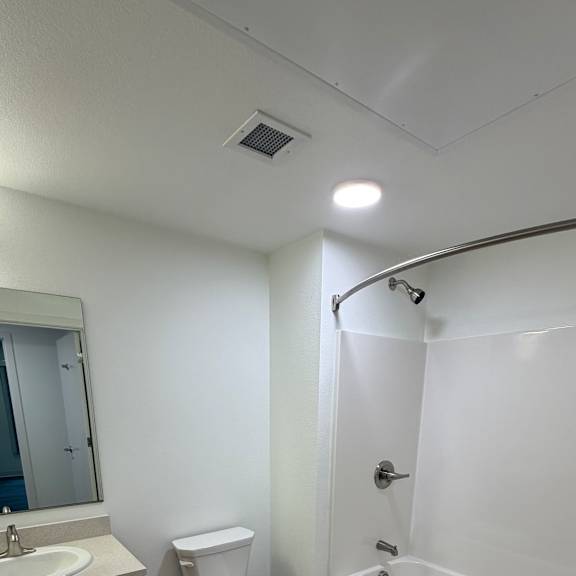 a white toilet sits in a bathroom next to a sink and a bathtub.