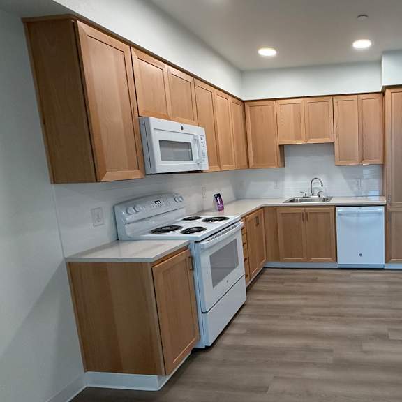 a kitchen with wooden cabinets and white appliances.