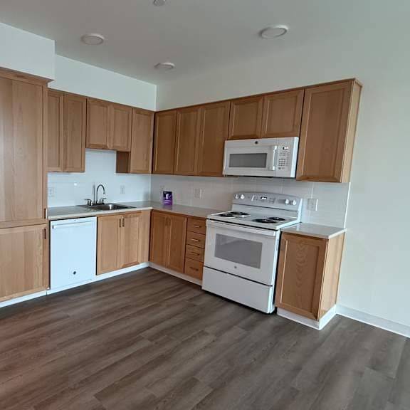 a kitchen with white appliances and wooden cabinets.