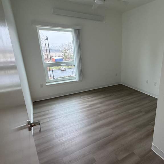 a room with a window and a wooden floor.