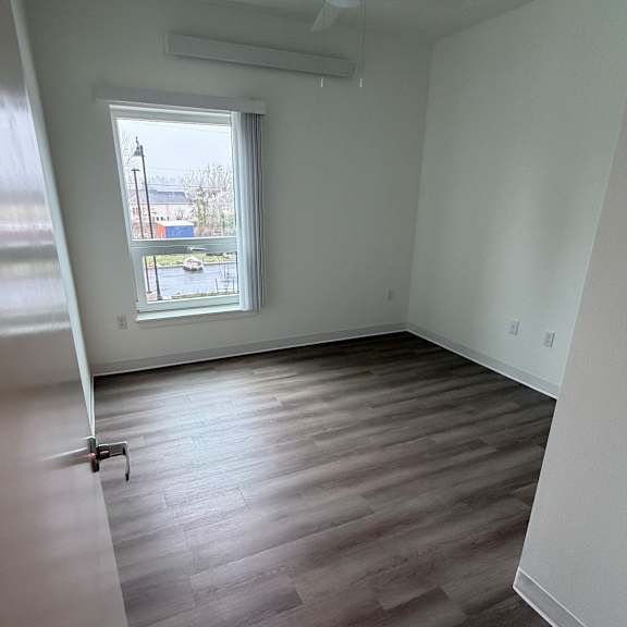 a room with a window and a ceiling fan.