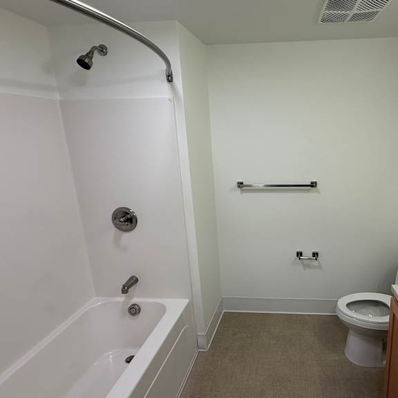 a white bathroom with a toilet, sink, and bathtub.