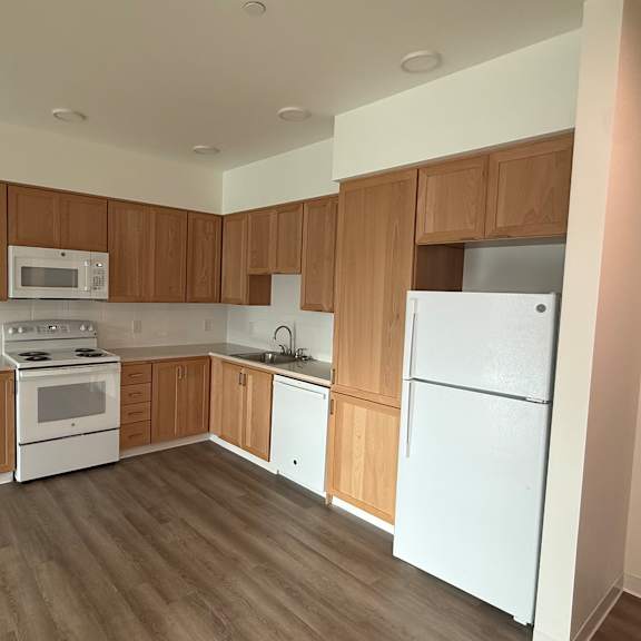 a kitchen with white appliances and wooden cabinets.