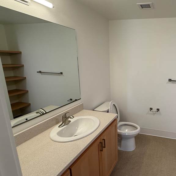 a bathroom with a sink, toilet, and stairs.