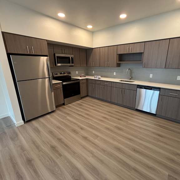 a modern kitchen with wooden cabinets and stainless steel appliances.
