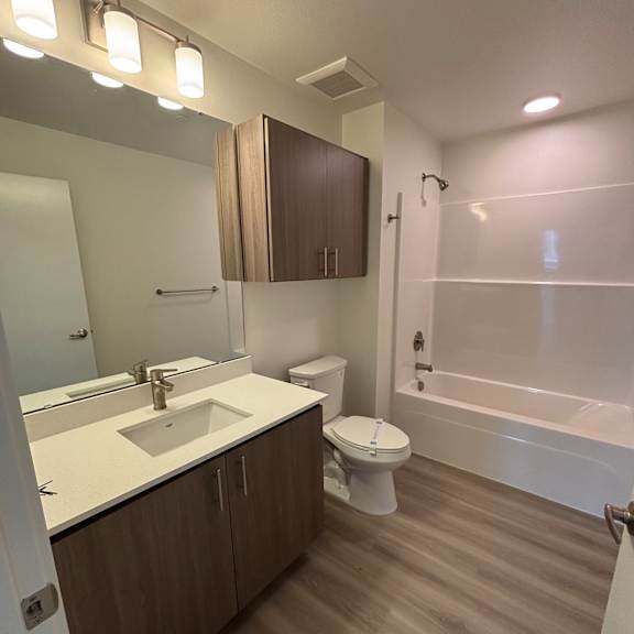 a modern bathroom with a wooden countertop and white walls.