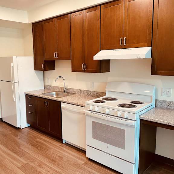 a kitchen with white appliances and brown cabinets
