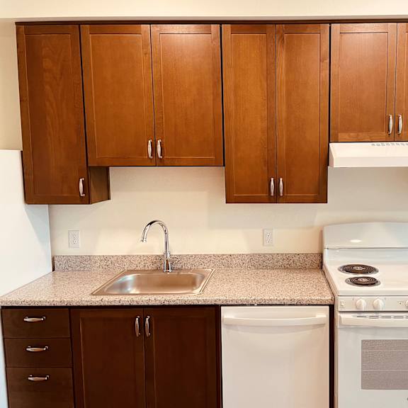 a kitchen with brown cabinets and white appliances