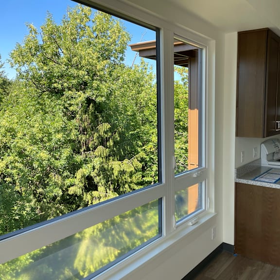 a kitchen with a large window and a view of a tree