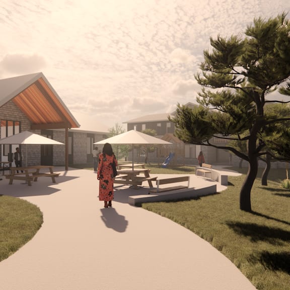 a woman in a red dress walks down a path in a park-like setting.