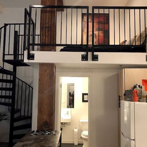 a kitchen with a table and chairs and a staircase.