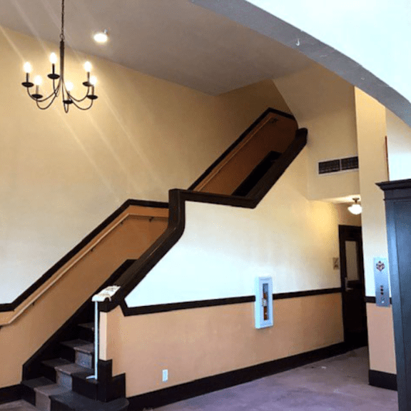 a staircase with a chandelier hanging above it.
