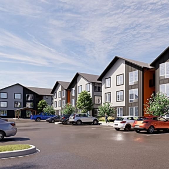 a row of modern townhouses with cars parked in front.
