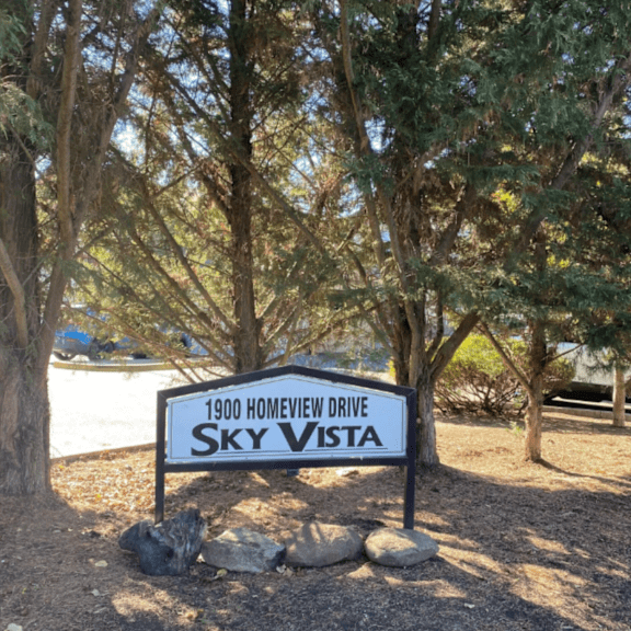 view of sky vista property sign surrounded by trees