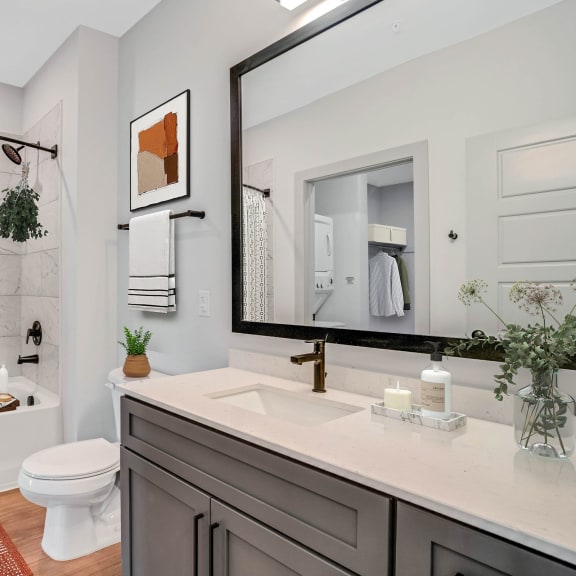 Thumbnail 9 of 11 a bathroom with a large mirror and a sink and a toilet