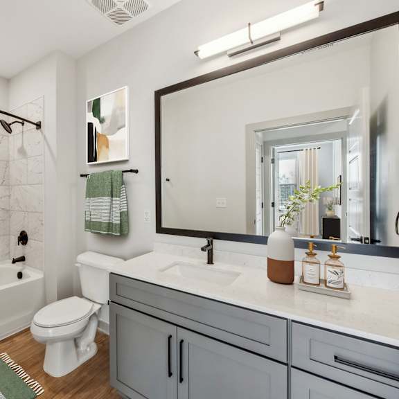 Thumbnail 10 of 10 A bathroom with a white toilet, a white sink, and a green shower curtain.