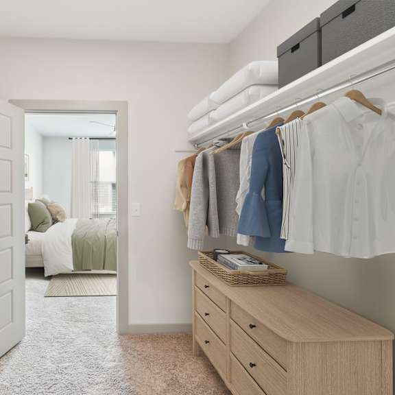 Thumbnail 10 of 21 A bedroom with a white door and a wardrobe with clothes hanging on it.