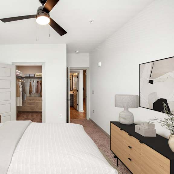 Thumbnail 8 of 10 A bedroom with a large bed and a ceiling fan.