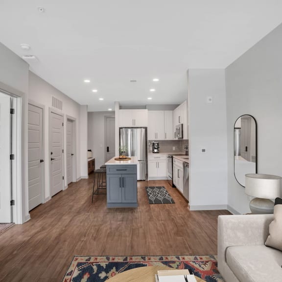 Thumbnail 4 of 11 a living room and kitchen with white walls and wood floors