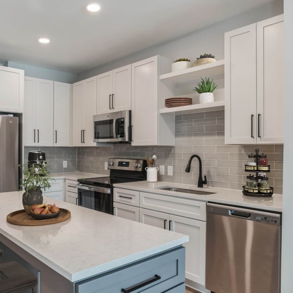 Thumbnail 10 of 11 a kitchen with white cabinets and stainless steel appliances