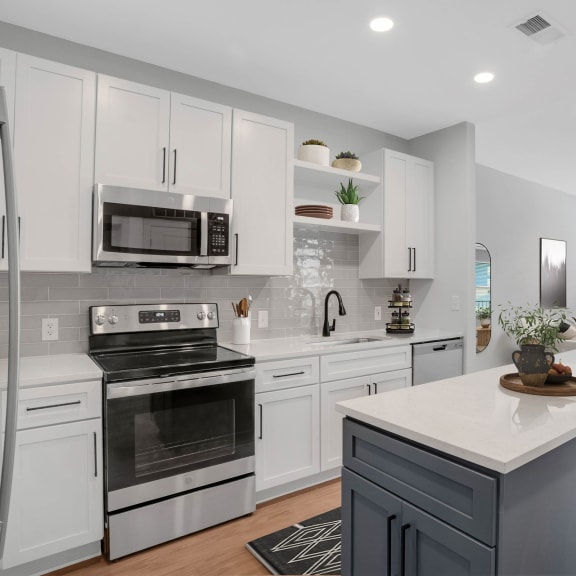 Thumbnail 2 of 11 a kitchen with white cabinets and stainless steel appliances