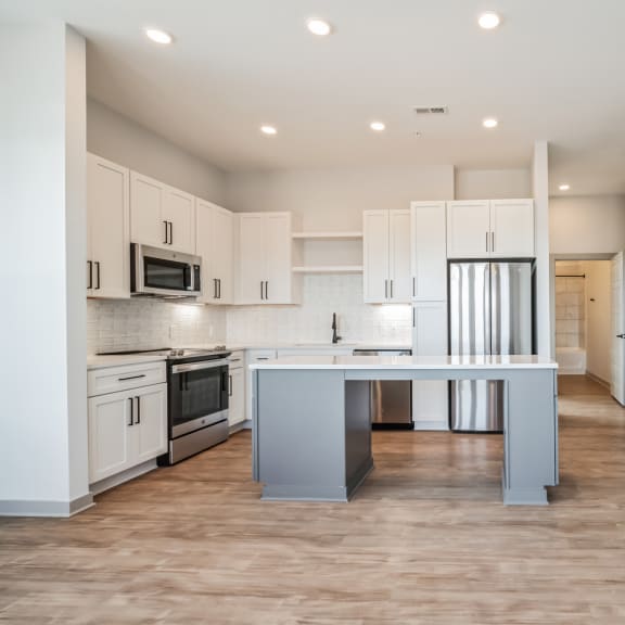 Thumbnail 5 of 21 a kitchen with white cabinets and stainless steel appliances and a blue island at Preston Ridge, North Carolina