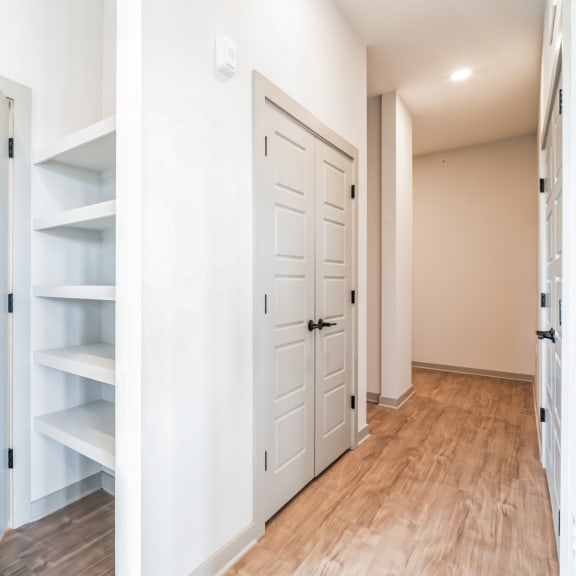 Thumbnail 9 of 21 a walk in closet with white doors and a wood floor at Preston Ridge, North Carolina