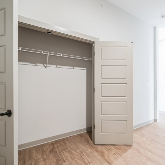 Thumbnail 15 of 21 an empty bedroom with an open closet with a white door at Preston Ridge, Cary, 27513