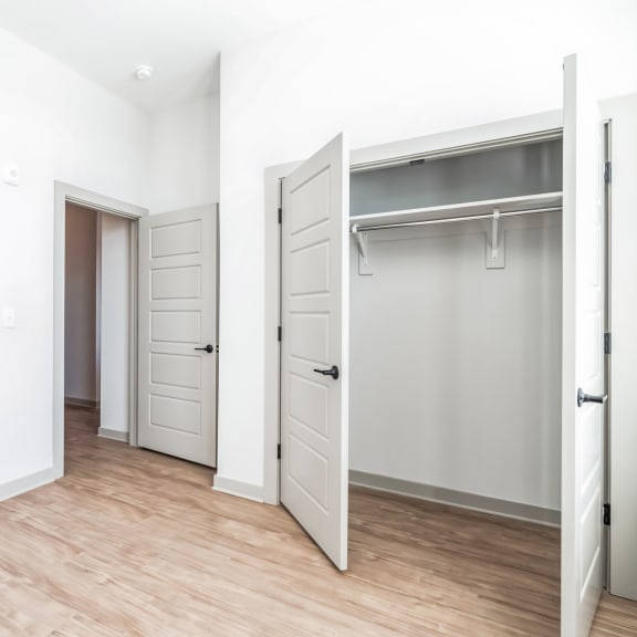 Thumbnail 12 of 21 an empty room with white walls and a closet with a door at Preston Ridge, Cary