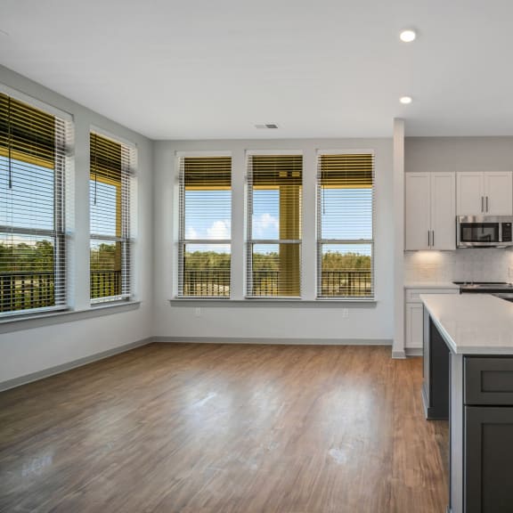 Thumbnail 6 of 21 an empty kitchen with a large island in the center at Preston Ridge, North Carolina, 27513