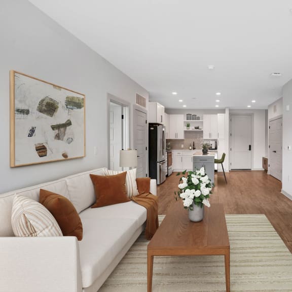 Thumbnail 5 of 12 a living room with a white couch and a wooden table