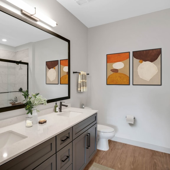Thumbnail 11 of 12 a bathroom with a large mirror and a sink and a toilet