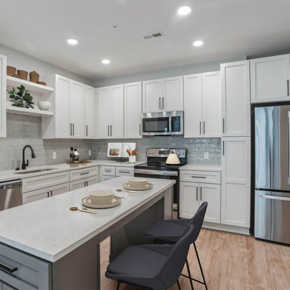 Thumbnail 2 of 9 a large kitchen with white cabinets and stainless steel appliances