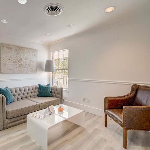 A living room with a grey couch and a brown chair.