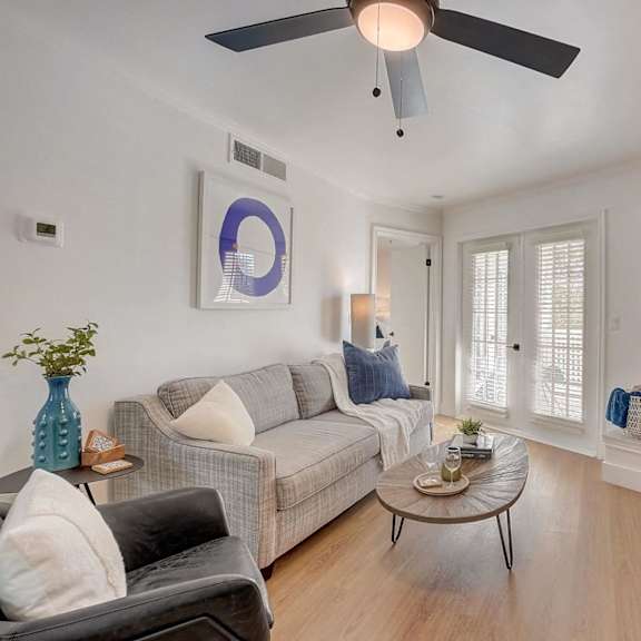A living room with a grey couch, a coffee table, and a fireplace.