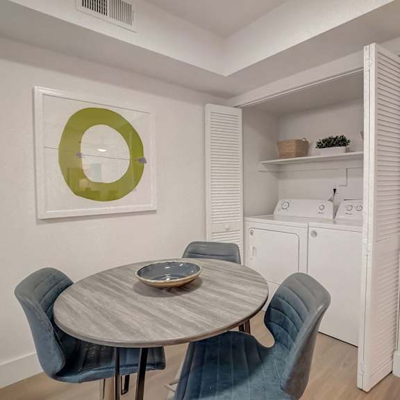 A dining room with a round table and chairs.