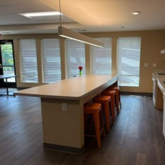 a kitchen with a long counter and bar stools.