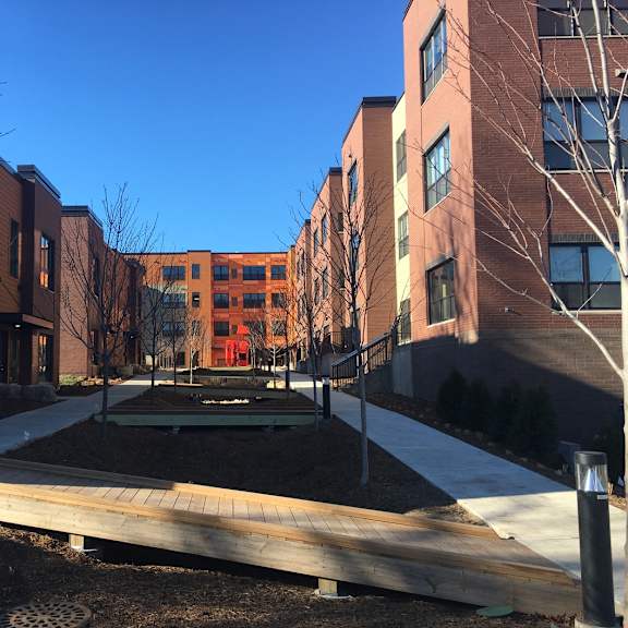 a courtyard surrounded by buildings with a playground in the middle.