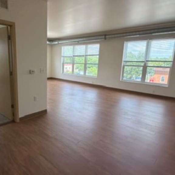 a room with a wooden floor and a doorway leading to another room.