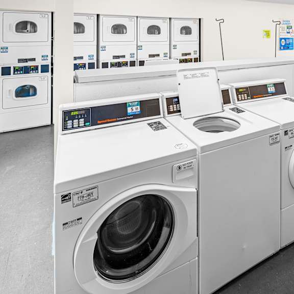 a row of industrial washing machines in a laundromat.