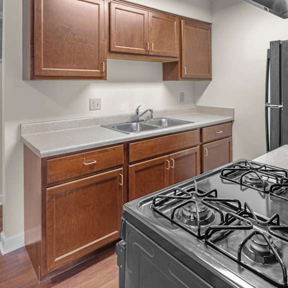 a kitchen with a black stove and wooden cabinets.