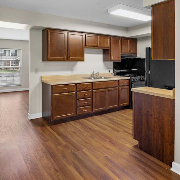 a kitchen with wooden cabinets and a black refrigerator.