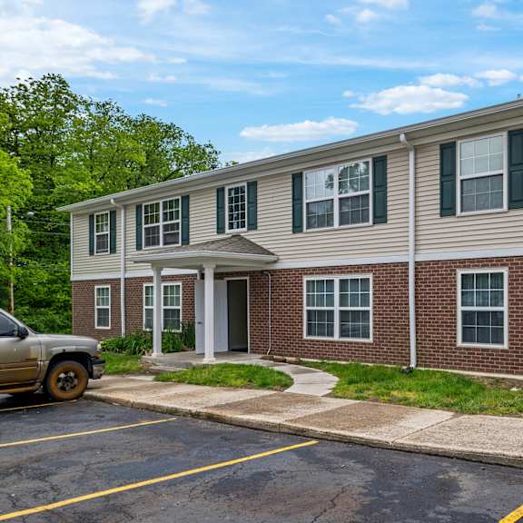 a two-story building with a parking lot in front.