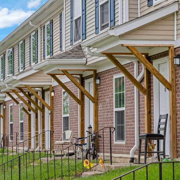 a house with a porch and a bicycle on the lawn.