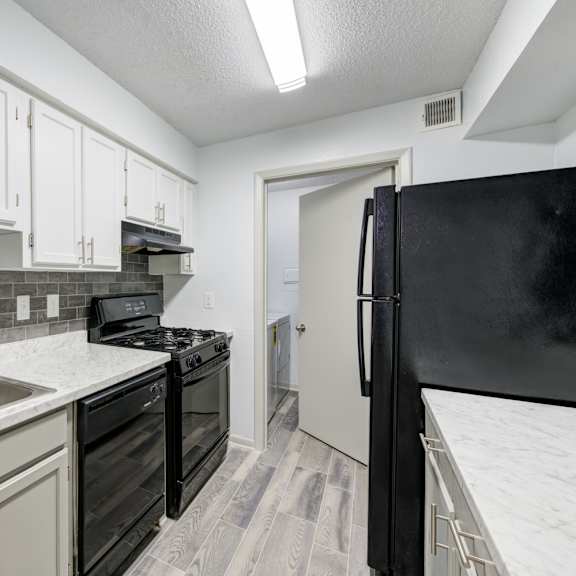 a kitchen with black appliances and white cabinets in raleigh, nc