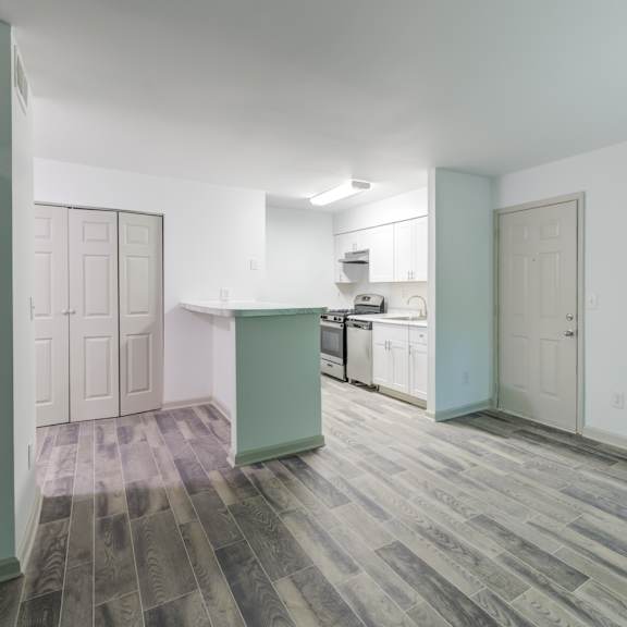 a renovated kitchen and living room with luxury vinyl floors at laurel oaks in raleigh, nc