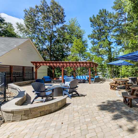 an outdoor lounge with a table and chairs under an umbrella.