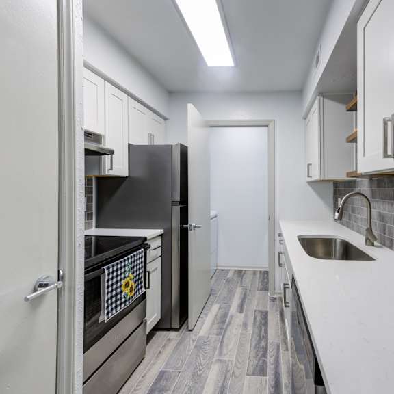 a kitchen with a black fridge and a white sink.